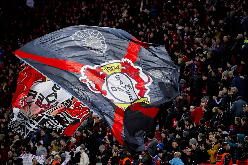 Aficionados del Bayer Leverkusen en la grada durante un partido con una enorme bandera